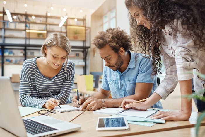 cerca-grupo-jovenes-iniciadores-sentados-biblioteca-haciendo-investigaciones-sobre-proyectos-futuros-mirando-traves-graficos-computadora-portatil-escribiendo-nuevas-ideas (1)