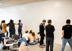 Students standing in front of a blackboard in a CIB creativity workshop